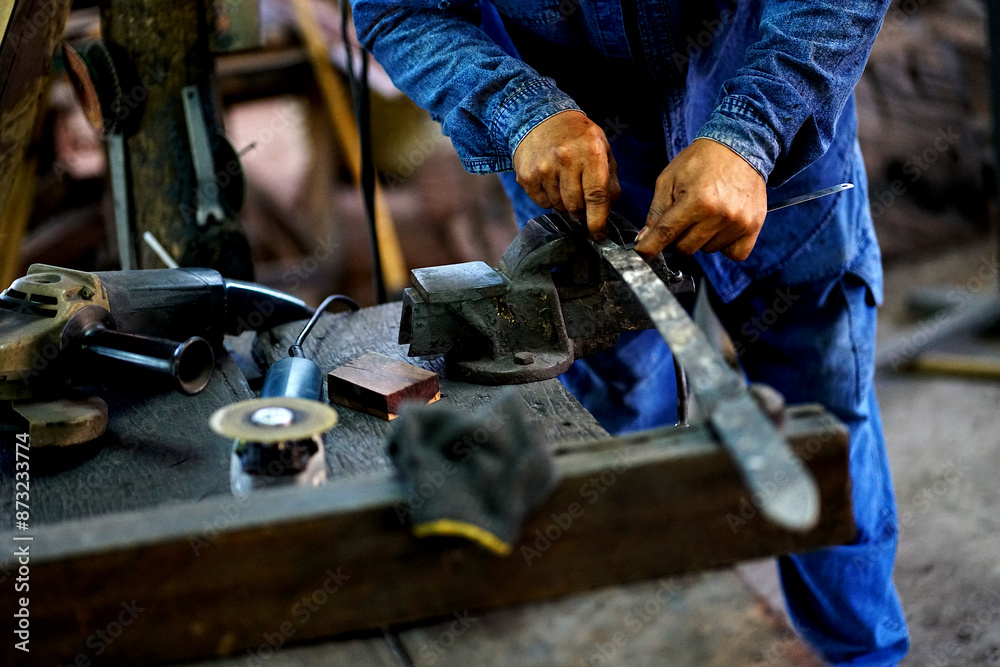 Blacksmith working with steel, forging and inspecting the iron steel sword Blacksmith working with steel, forging and inspecting the iron steel sword