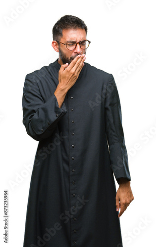 Adult hispanic catholic priest man over isolated background bored yawning tired covering mouth with hand. Restless and sleepiness.