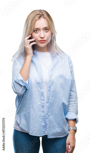 Young blonde woman talking using smarpthone over isolated background with a confident expression on smart face thinking serious