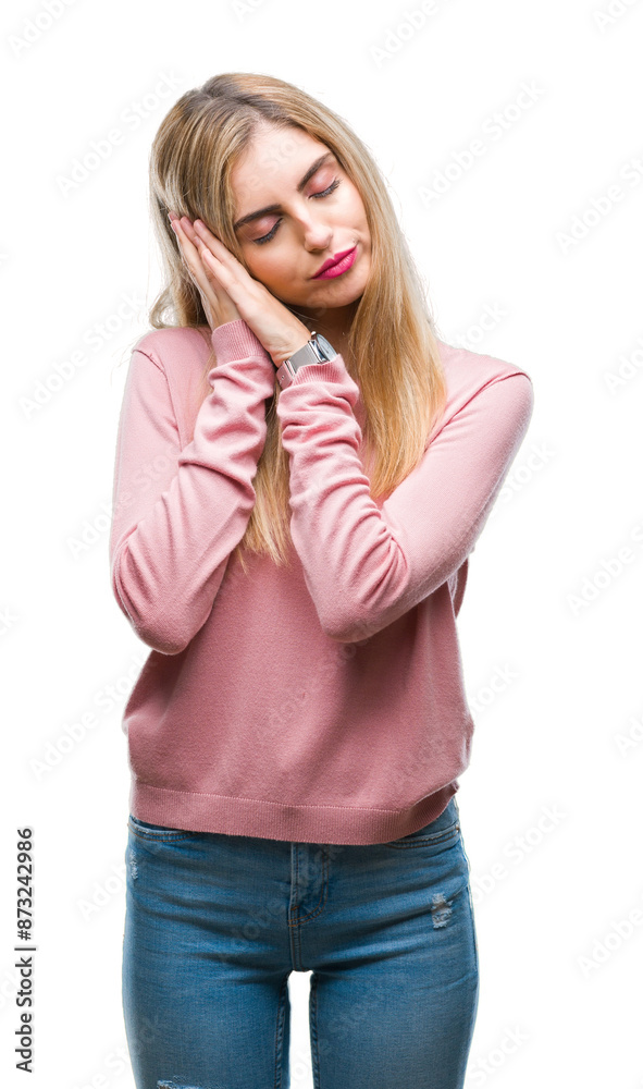 Young beautiful blonde woman wearing pink winter sweater over isolated background sleeping tired dreaming and posing with hands together while smiling with closed eyes. Young beautiful blonde woman wearing pink winter sweater over isolated background sleeping tired dreaming and posing with hands together while smiling with closed eyes.