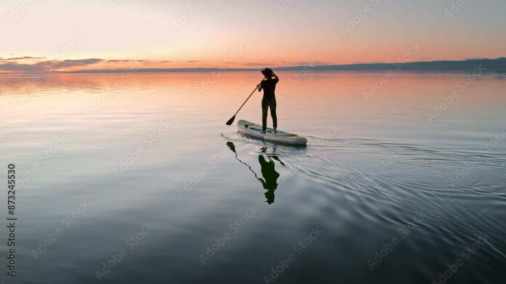 Young sporty lady walks on standup paddle sup board at sunset calm lake. Active vacations concept
