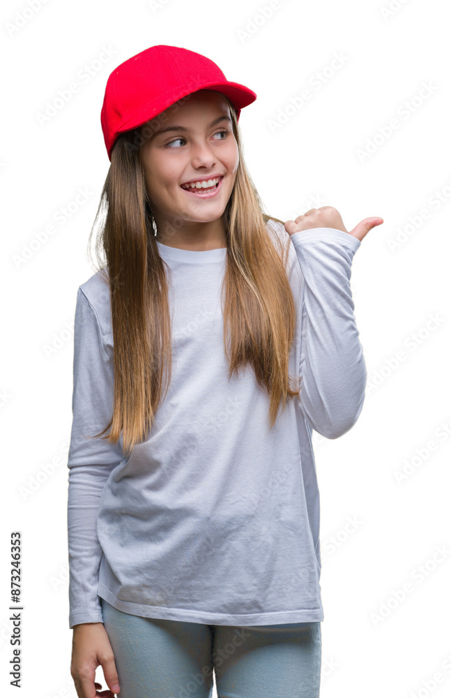 Young beautiful girl wearing red cap isolated background smiling with happy face looking and pointing to the side with thumb up. Young beautiful girl wearing red cap isolated background smiling with happy face looking and pointing to the side with thumb up.