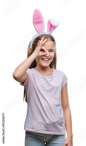 Young beautiful girl wearing easter bunny ears over isolated background doing ok gesture with hand smiling, eye looking through fingers with happy face.