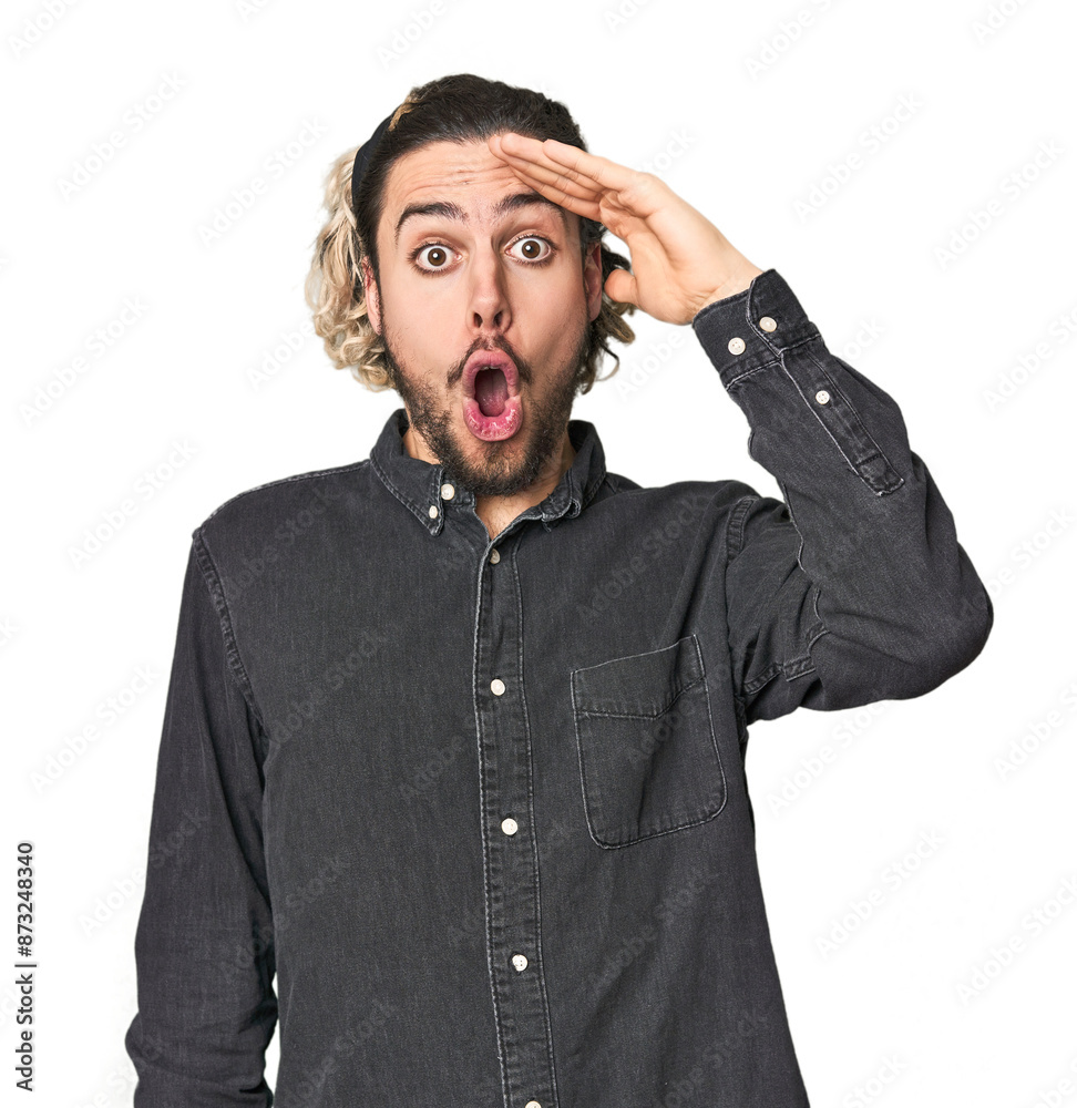 Young Caucasian man in studio setting shouts loud, keeps eyes opened and hands tense. Young Caucasian man in studio setting shouts loud, keeps eyes opened and hands tense.