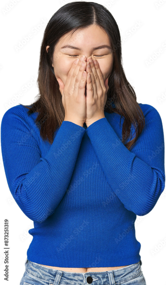 Young Chinese woman laughing about something, covering mouth with hands. Young Chinese woman laughing about something, covering mouth with hands.