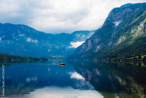 Fototapeta Naklejka Na Ścianę i Meble -  Beautiful view of Bohinj lake and lonely boat on the background of the mountains, Slovenia