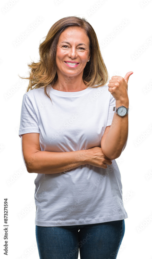 Middle age senior hispanic woman over isolated background smiling with happy face looking and pointing to the side with thumb up. Middle age senior hispanic woman over isolated background smiling with happy face looking and pointing to the side with thumb up.