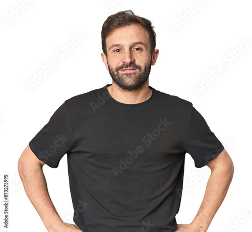 Studio portrait of young Hispanic male confident keeping hands on hips.