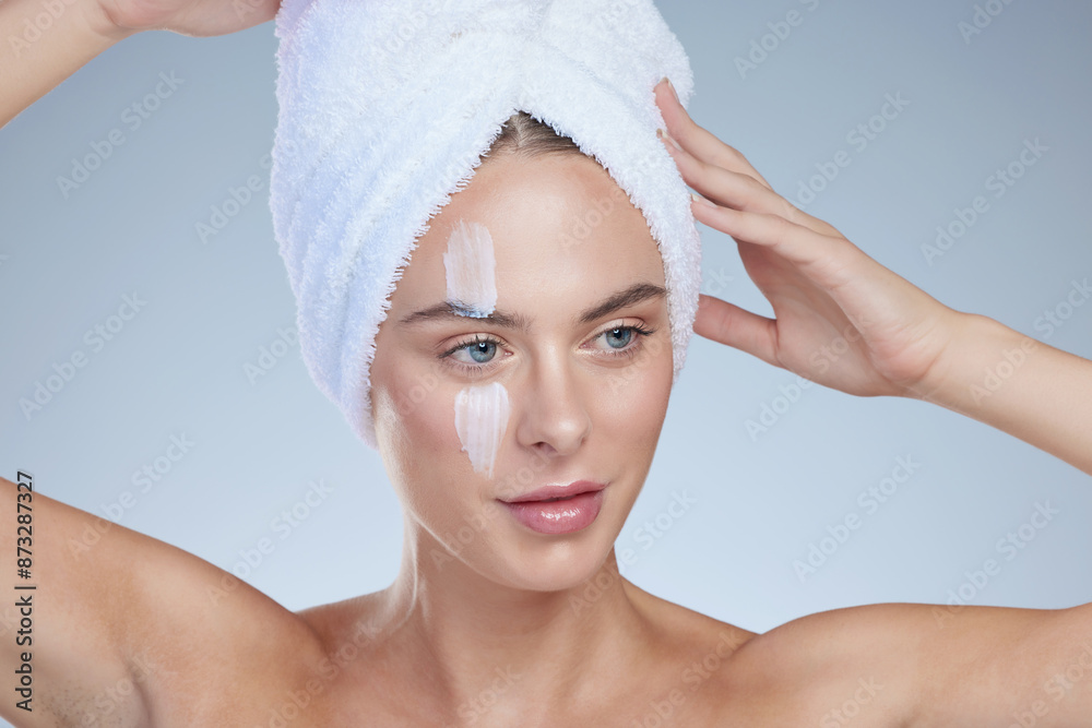 Woman, skincare and thinking in studio with cream for hydration, wellness or cosmetics. Towel, model girl and idea for beauty and lotion for dermatology, collagen or anti ageing by white background Woman, skincare and thinking in studio with cream for hydration, wellness or cosmetics. Towel, model girl and idea for beauty and lotion for dermatology, collagen or anti ageing by white background