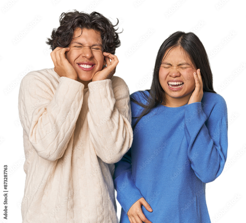 Young interracial couple in studio covering ears with hands. Young interracial couple in studio covering ears with hands.
