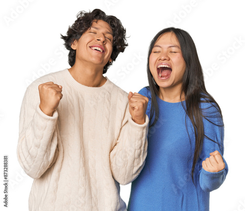 Фотография Young interracial couple in studio celebrating a victory, passion and enthusiasm, happy expression