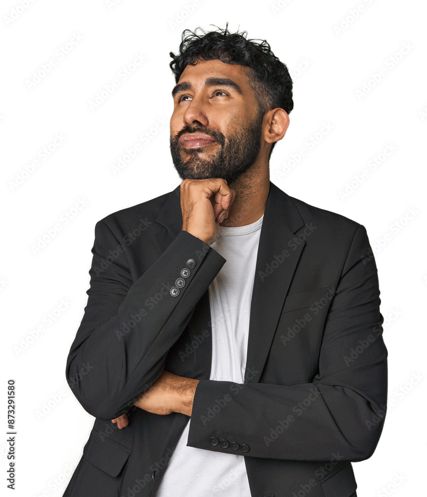 Hispanic businessman in suit in studio thinking and looking up, being reflective, contemplating, having a fantasy. Hispanic businessman in suit in studio thinking and looking up, being reflective, contemplating, having a fantasy.