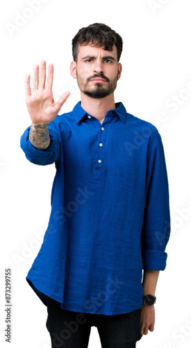 Young handsome man over isolated background doing stop sing with palm of the hand. Warning expression with negative and serious gesture on the face.