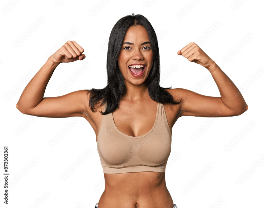Young Filipino woman in light wear showing strength gesture with arms, symbol of feminine power Young Filipino woman in light wear showing strength gesture with arms, symbol of feminine power