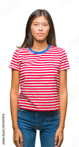 Young asian woman over isolated background with serious expression on face. Simple and natural looking at the camera.