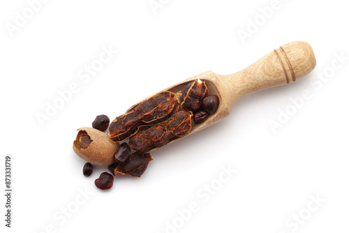 Top view of a wooden scoop filled with Fresh Organic Sweet Tamarind (Tamarindus indica) Fruit. Isolated on a white background. photo