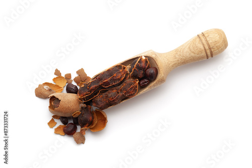 Top view of a wooden scoop filled with Fresh Organic Sweet Tamarind (Tamarindus indica) Fruit. Isolated on a white background. photo