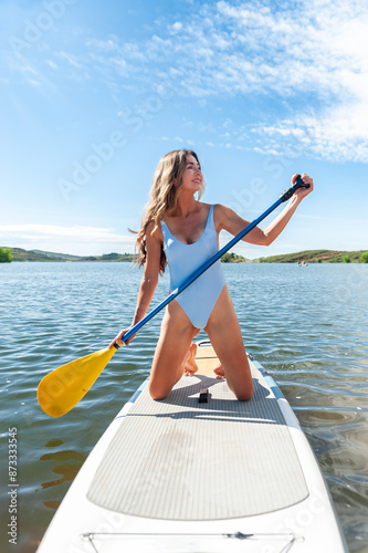 Young woman paddling a stand-up paddle board