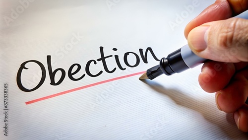 Hand with marker writing the word Objection photo