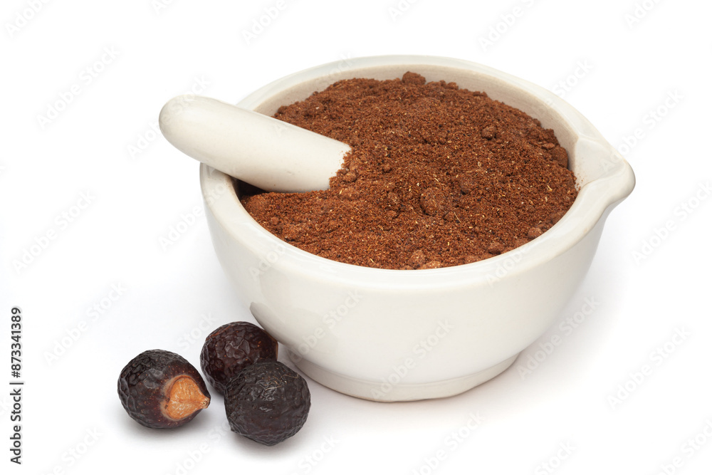 Close-up of Organic Soapnut or Reetha (Sapindus mukorossi) powder with its Fruits, in white ceramic mortar and pestle, isolated on a white background. Close-up of Organic Soapnut or Reetha (Sapindus mukorossi) powder with its Fruits, in white ceramic mortar and pestle, isolated on a white background.