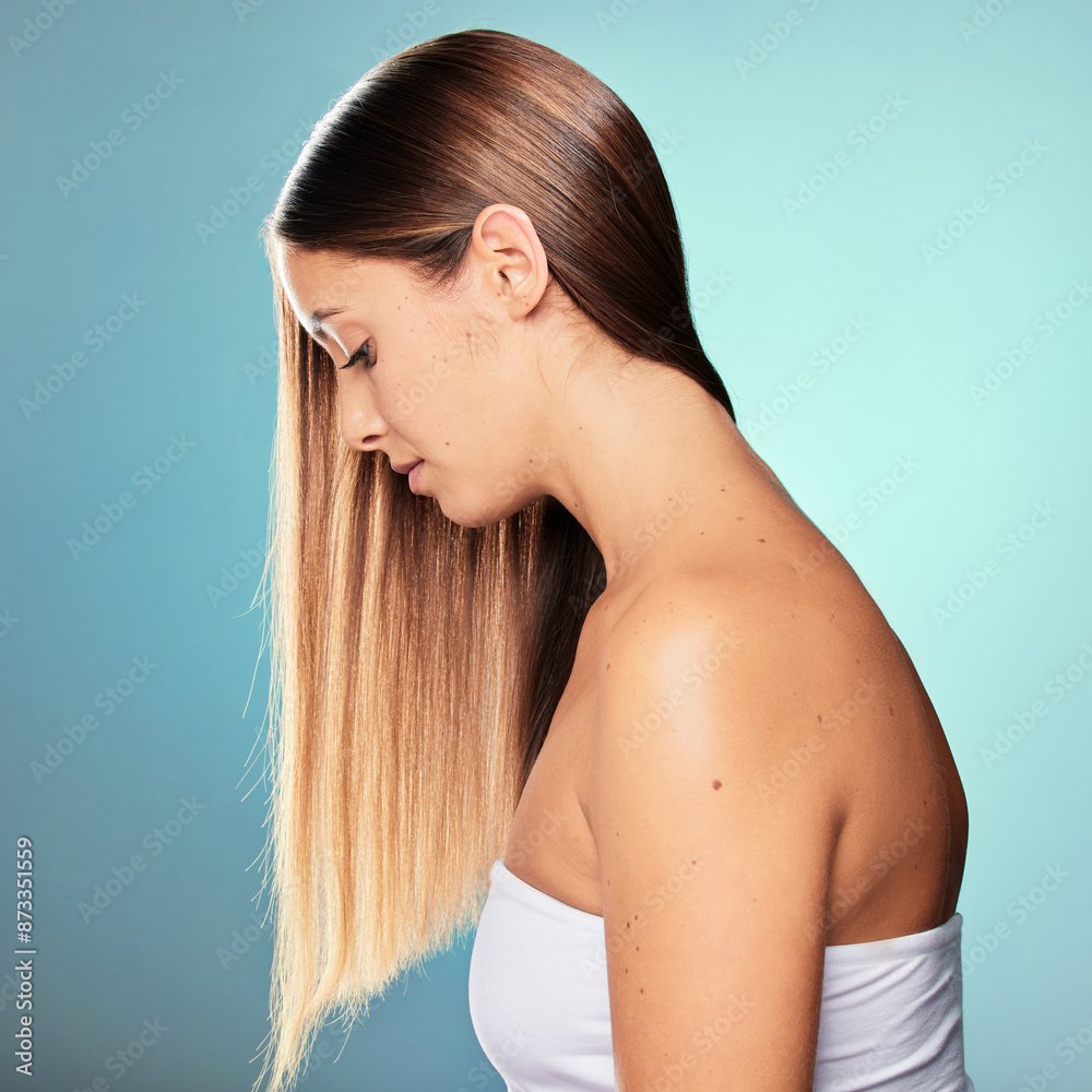 Naklejka premium Shine, long and woman with hair care, wellness or pride for cosmetics, results and keratin treatment. Relax, girl or model in studio on blue background for healthy glow, natural growth and beauty