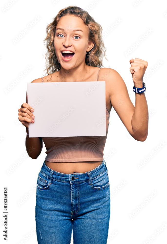 Naklejka premium Beautiful caucasian woman holding blank empty banner screaming proud, celebrating victory and success very excited with raised arms