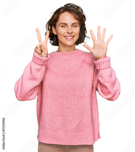 Young hispanic woman wearing casual clothes showing and pointing up with fingers number seven while smiling confident and happy.
