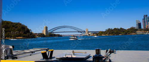 Captivating shot of Sydney Harbour Bridge from a vibrant yellow boat. Iconic skyline, lush greenery, and architectural wonders make this a stunning snapshot of Sydney, Australia