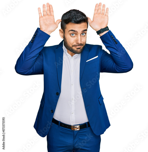 Fotografía Young hispanic man wearing business jacket doing bunny ears gesture with hands palms looking cynical and skeptical