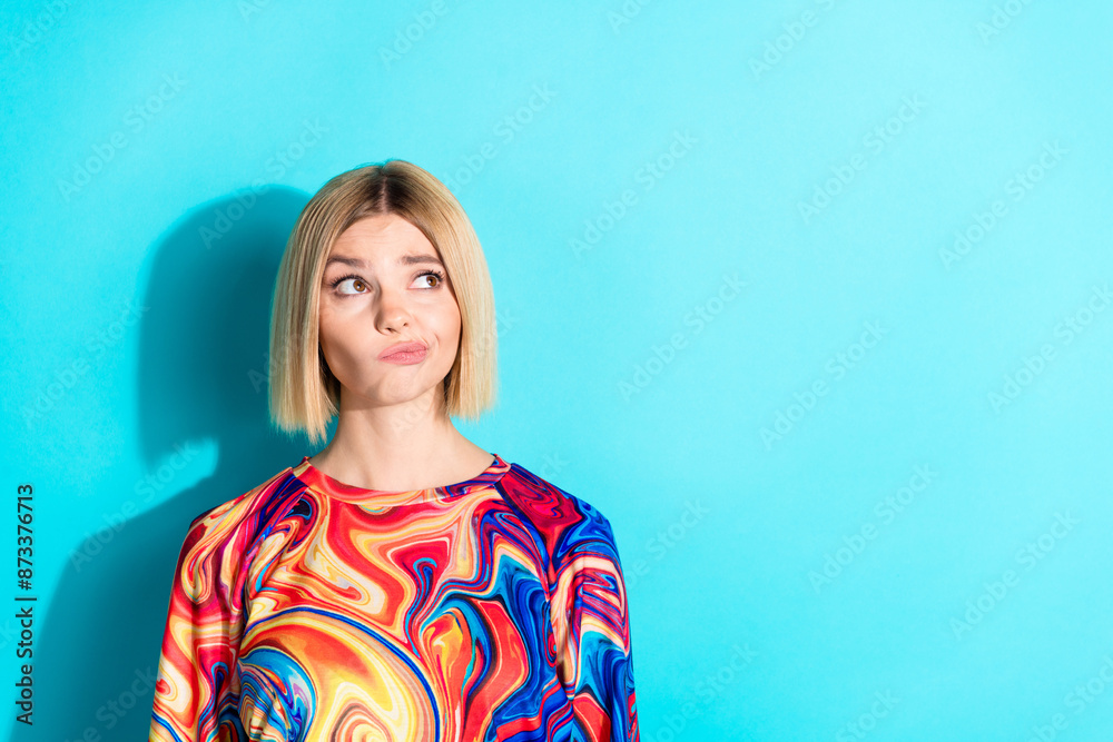 Fototapeta premium Photo of minded girl with bob hairstyle dressed print shirt thoughtfully look empty space offer isolated on turquoise color background