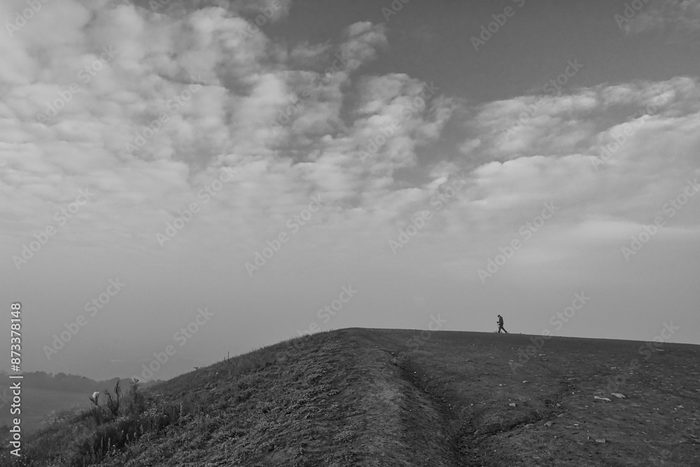 Fototapeta premium man walking up a hill