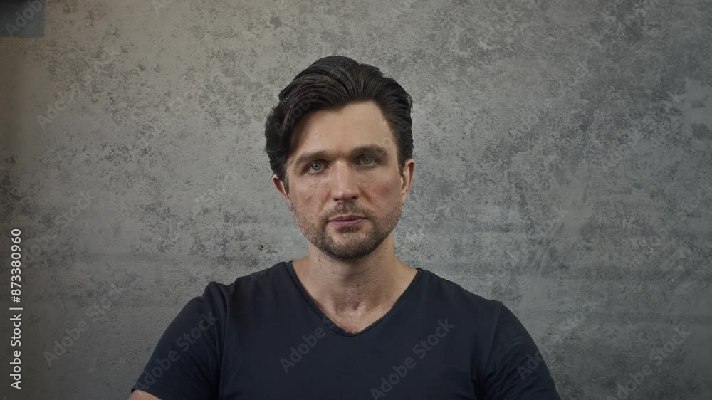 Medium portrait of elegant middle-aged Caucasian man with stylish hairdo wearing black T-shirt posing for camera on gray background Medium portrait of elegant middle-aged Caucasian man with stylish hairdo wearing black T-shirt posing for camera on gray background