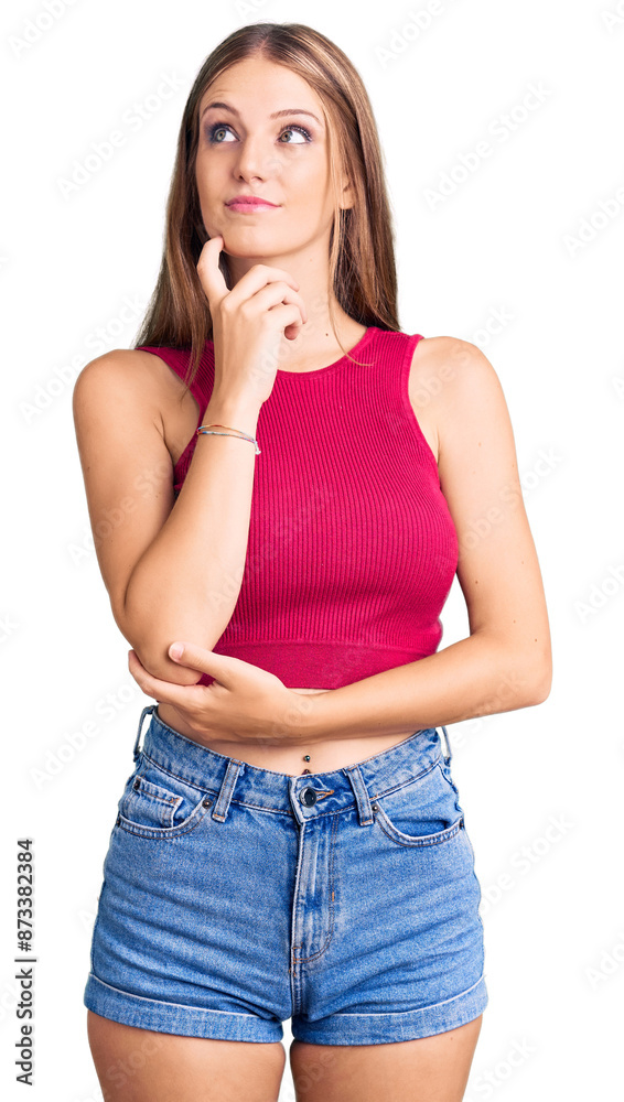 Young beautiful blonde woman wearing elegant summer shirt with hand on chin thinking about question, pensive expression. smiling with thoughtful face. doubt concept. Young beautiful blonde woman wearing elegant summer shirt with hand on chin thinking about question, pensive expression. smiling with thoughtful face. doubt concept.