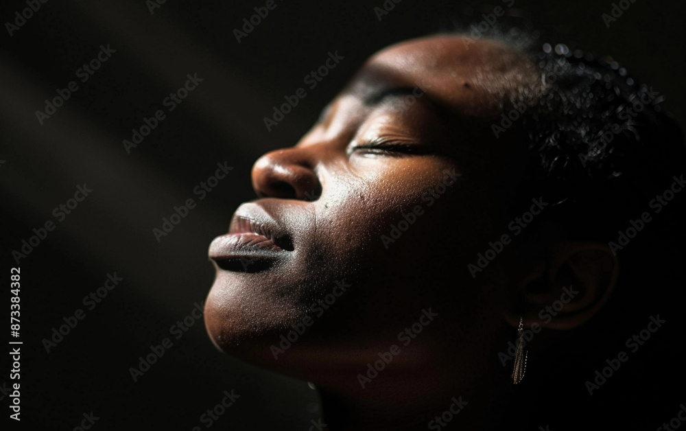 A close-up portrait of an African American celebrity stylist with their eyes closed A close-up portrait of an African American celebrity stylist with their eyes closed