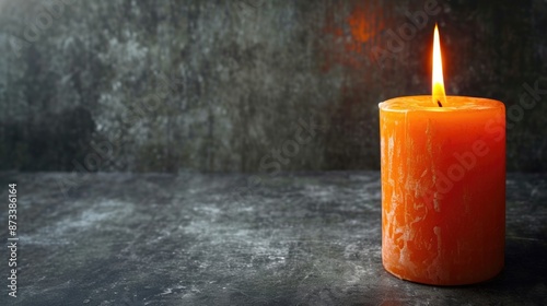 Wallpaper Mural A lit orange candle sits on a grey surface. The candle is the only object in the image, and it is the main focus. The candle's warm glow creates a cozy and intimate atmosphere Torontodigital.ca