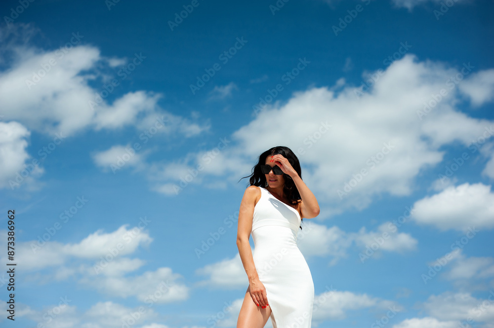 Perfect fashion vogue woman on resort wearing white dress and walking on sand beach Perfect fashion vogue woman on resort wearing white dress and walking on sand beach
