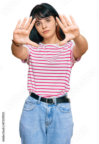 Young hispanic girl wearing casual clothes doing frame using hands palms and fingers, camera perspective