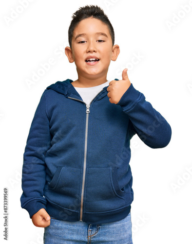 Little boy hispanic kid wearing casual sporty jacket smiling happy and positive, thumb up doing excellent and approval sign photo