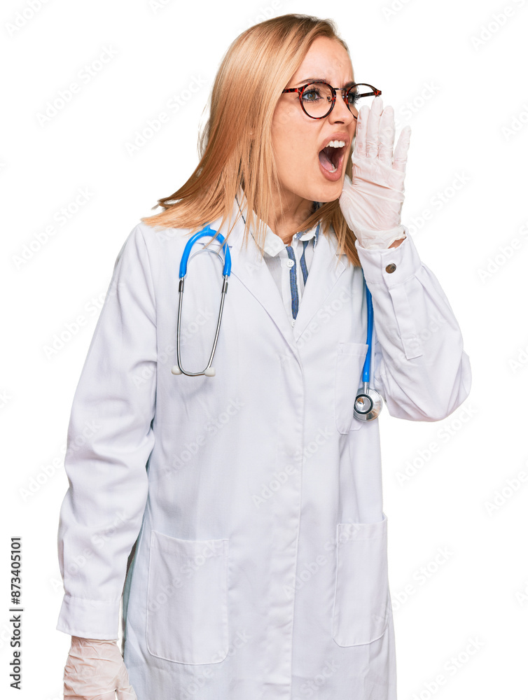 Beautiful caucasian woman wearing doctor uniform and stethoscope shouting and screaming loud to side with hand on mouth. communication concept. Beautiful caucasian woman wearing doctor uniform and stethoscope shouting and screaming loud to side with hand on mouth. communication concept.