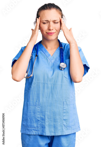 Young beautiful blonde woman wearing doctor uniform and stethoscope with hand on head for pain in head because stress. suffering migraine.