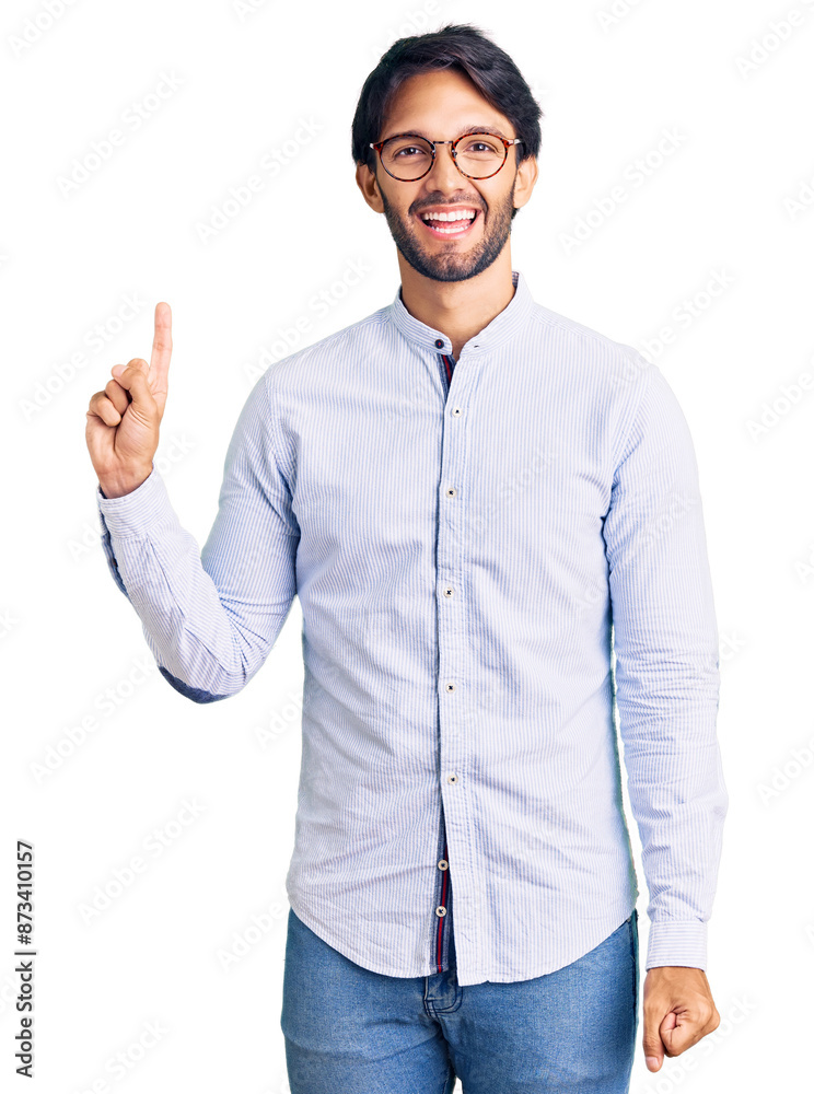 Handsome hispanic man wearing business shirt and glasses showing and pointing up with finger number one while smiling confident and happy. Handsome hispanic man wearing business shirt and glasses showing and pointing up with finger number one while smiling confident and happy.