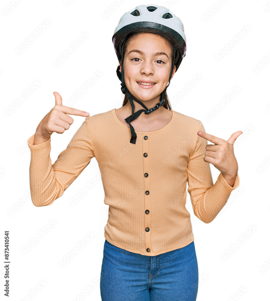 Beautiful brunette little girl wearing bike helmet looking confident with smile on face, pointing oneself with fingers proud and happy. Beautiful brunette little girl wearing bike helmet looking confident with smile on face, pointing oneself with fingers proud and happy.