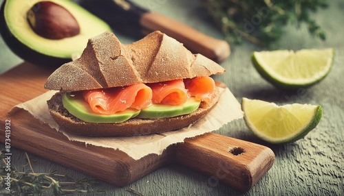Sandwich with salmon, avocado and spices, homemade bread, vintage toned photo