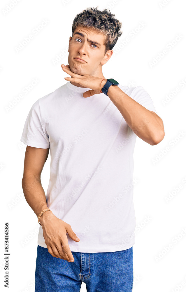 Young handsome man wearing casual white tshirt cutting throat with hand as knife, threaten aggression with furious violence Young handsome man wearing casual white tshirt cutting throat with hand as knife, threaten aggression with furious violence