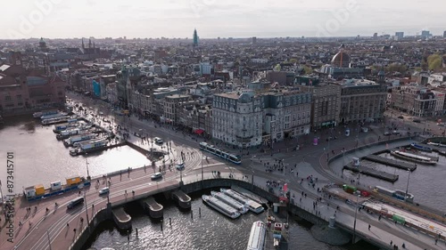 Enjoy a stunning aerial view of Amsterdams dynamic cityscape, featuring its renowned canals, historic structures, and lively streets. Ideal for urban, travel, and architectural enthusiasts photo