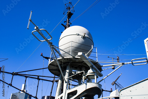 Captivating view of an Australian naval warship in the Tasman Sea, featuring a striking round tank atop the vessel. Below, a complex network of stairs and numerous pipes adds an industrial charm.