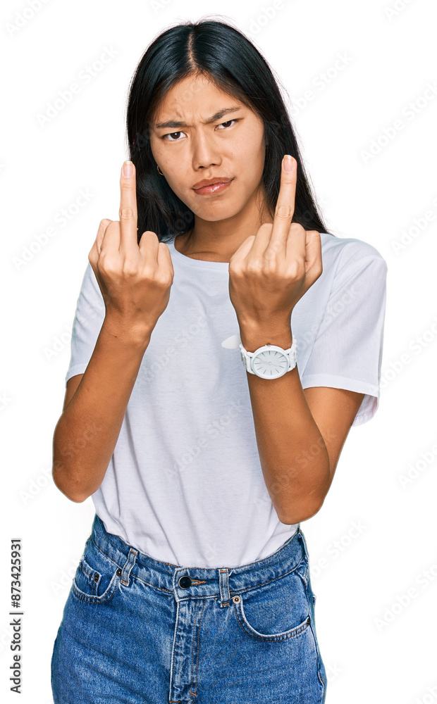Beautiful young asian woman wearing casual white t shirt showing middle finger doing fuck you bad expression, provocation and rude attitude. screaming excited Beautiful young asian woman wearing casual white t shirt showing middle finger doing fuck you bad expression, provocation and rude attitude. screaming excited