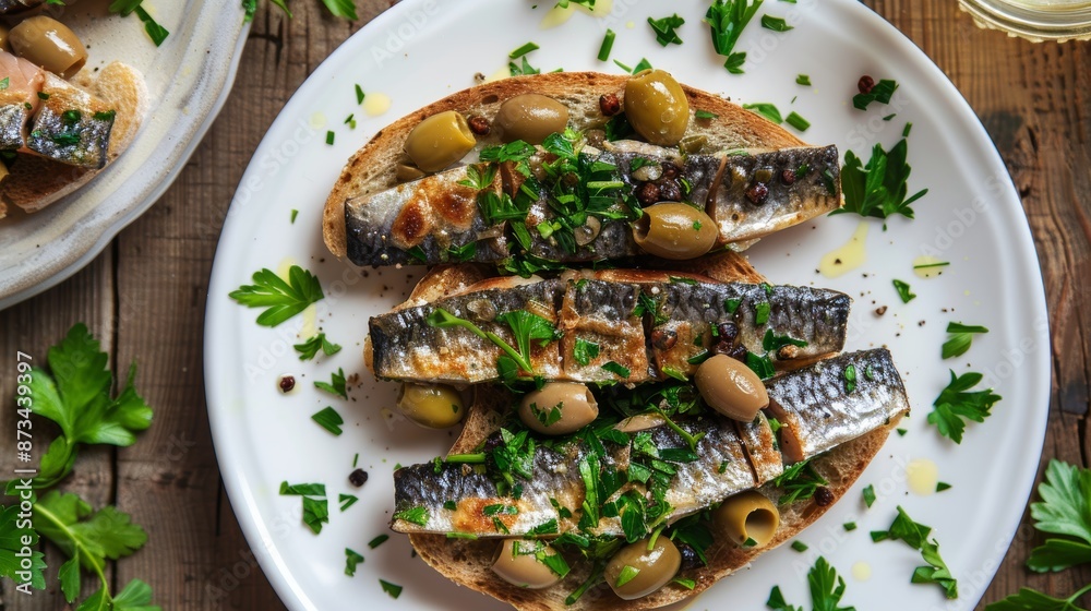 Sandwich: smorrebrod on a wooden platter with butter, green olives, and sprats. Danish cooking. top perspective, above, and level lie Sandwich: smorrebrod on a wooden platter with butter, green olives, and sprats. Danish cooking. top perspective, above, and level lie