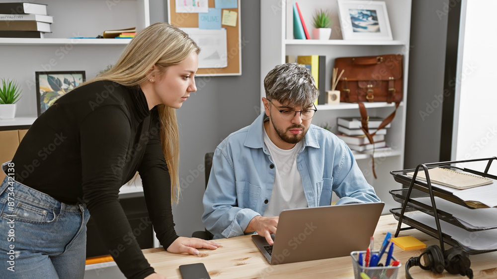 A man and woman collaborate in a modern office, showcasing teamwork and professionalism amidst technology and office supplies. A man and woman collaborate in a modern office, showcasing teamwork and professionalism amidst technology and office supplies.