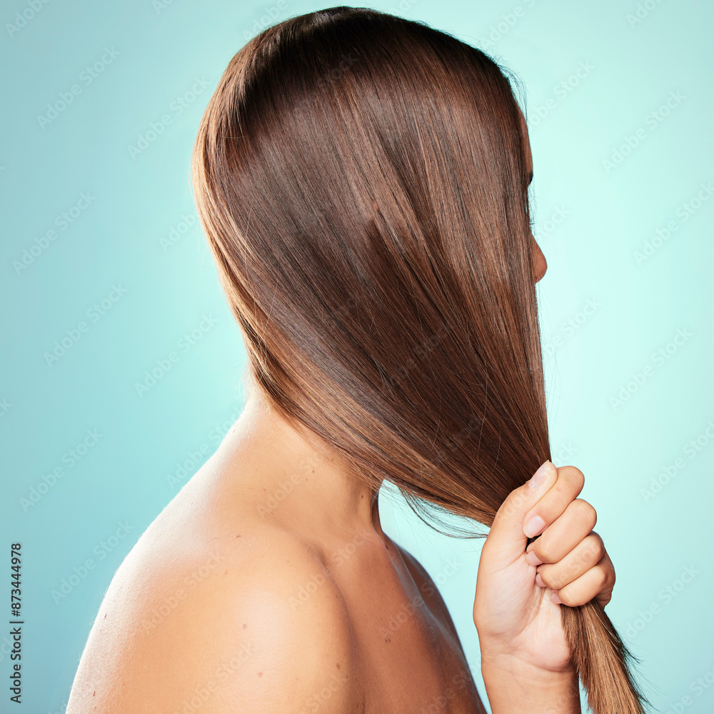 Fototapeta premium Strong hair, pull and woman with results, wellness or pride for cosmetics, glow or keratin treatment. Haircare, girl or model in studio on blue background for healthy shine, natural growth and beauty